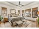 Serene main bedroom with large windows, tray ceiling, hardwood floors, and stylish decor at 583 Exmoor Dr, Carmel, IN 46032