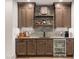 Finished basement wet bar features wood cabinetry, stone tile backsplash, and beverage refrigerator at 583 Exmoor Dr, Carmel, IN 46032