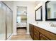 A bathroom with double sinks, wood cabinets, and a glass-door shower next to the main bedroom at 5875 Mill Haven Way, Noblesville, IN 46062