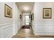 Inviting entryway with wood flooring, white wainscoting, and decorative framed artwork on the walls at 5875 Mill Haven Way, Noblesville, IN 46062