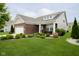 Attractive single-Gathering home featuring a well-maintained lawn, garden, and a cozy front porch seating area at 5875 Mill Haven Way, Noblesville, IN 46062