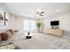 Comfortable living room features an L-shaped couch, accent rug, ceiling fan, and television at 5875 Mill Haven Way, Noblesville, IN 46062