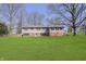 The view of the home shows a large manicured lawn, mature trees, and architectural details at 5913 W Maple Dr, Frankton, IN 46044