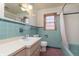 This vintage bathroom features a tub/shower, a vanity, a toilet and blue tile at 5913 W Maple Dr, Frankton, IN 46044