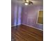 Simple bedroom with hardwood floors, ceiling fan, and single window for natural light at 6206 W Us Highway 40, Stilesville, IN 46180