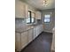 Clean kitchen featuring bright cabinets, laminate counters, stainless steel sink, and laminate flooring at 6206 W Us Highway 40, Stilesville, IN 46180