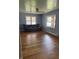 Simple living room with hardwood floors, a gray sofa, ceiling fan and two windows at 6206 W Us Highway 40, Stilesville, IN 46180