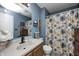 Well-lit bathroom with modern fixtures, a vanity with sink, and a decorative shower curtain at 6431 Meadowpond Way, Indianapolis, IN 46235