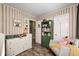 This delightful Bedroom includes striped walls, a changing table, a green bookshelf, and a cozy accent chair at 6431 Meadowpond Way, Indianapolis, IN 46235