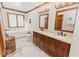 Luxurious bathroom features double sinks, wood cabinets, a soaking tub, and modern fixtures at 6712 Forrest Commons Blvd, Indianapolis, IN 46227