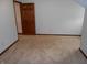 Cozy bedroom features neutral walls and plush carpet, with a door leading to another room at 6712 Forrest Commons Blvd, Indianapolis, IN 46227