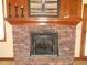 Close up view of brick fireplace with wood mantle, hearth and decor at 6712 Forrest Commons Blvd, Indianapolis, IN 46227