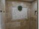 Custom tiled shower with a decorative plant and recessed niche for storage at 6712 Forrest Commons Blvd, Indianapolis, IN 46227