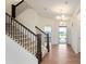 Bright foyer featuring wood floors, staircase with dark wood trim, and an open doorway to the outside at 6925 Sable Point Dr, Brownsburg, IN 46112