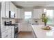 Close up of bright kitchen featuring white cabinets, stainless steel appliances, and an island at 6925 Sable Point Dr, Brownsburg, IN 46112