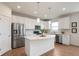Bright kitchen with stainless steel appliances, white cabinets, kitchen island, and wood floors at 6925 Sable Point Dr, Brownsburg, IN 46112
