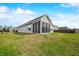 Back view of a house with a screened porch and a grassy yard under a blue sky at 7574 Merrick Dr, Brownsburg, IN 46112