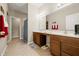 Bathroom featuring a double vanity with a large mirror, tile floors, and a hallway leading to the Primary closet at 7574 Merrick Dr, Brownsburg, IN 46112