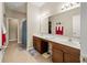 Bright bathroom featuring a double vanity with a large mirror and tile floors, with access to the Primary closet at 7574 Merrick Dr, Brownsburg, IN 46112
