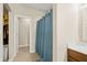 Bathroom with tile floors and a shower behind a teal curtain, next to a doorway leading to the Primary closet at 7574 Merrick Dr, Brownsburg, IN 46112