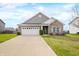 Traditional home exterior featuring a brick facade, manicured lawn, and an attached two-car garage beneath a partly cloudy sky at 7574 Merrick Dr, Brownsburg, IN 46112