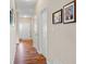 Bright hallway featuring wood-look flooring, neutral paint, and decorative wall art leading into the home's living spaces at 7574 Merrick Dr, Brownsburg, IN 46112