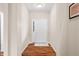 Hallway view featuring light walls, attractive wood-look flooring, and a clear view of the front entrance door at 7574 Merrick Dr, Brownsburg, IN 46112