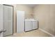A simple laundry room featuring white appliances, neutral colored paint, and vinyl flooring at 7574 Merrick Dr, Brownsburg, IN 46112