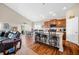 Open-concept living area with breakfast bar, hardwood floors, and a large leather couch providing comfortable seating at 7574 Merrick Dr, Brownsburg, IN 46112
