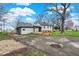 Exterior view of a backyard featuring a two-story home, wood deck, large yard with a tree, and blue sky at 7609 Camby Rd, Indianapolis, IN 46113