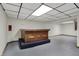 Large basement area featuring a gray floor, paneled ceiling with recessed lighting, and a display stand at 7609 Camby Rd, Indianapolis, IN 46113