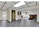 Basement area featuring a bar, gray floor, wooden shelving, brick features, and paneled ceiling with recessed lighting at 7609 Camby Rd, Indianapolis, IN 46113