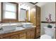 Charming bathroom showcasing double sinks, granite counters, decorative fixtures, and rustic wood trim at 7609 Camby Rd, Indianapolis, IN 46113
