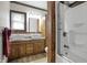 Stylish bathroom features double sinks, granite counters, decorative fixtures, rustic wood trim, and tiled shower at 7609 Camby Rd, Indianapolis, IN 46113