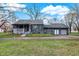 Charming stone home featuring an inviting front porch and an attached garage at 7609 Camby Rd, Indianapolis, IN 46113