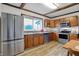 Modern kitchen with stainless steel appliances and wooden cabinetry, complemented by bright natural light at 7609 Camby Rd, Indianapolis, IN 46113
