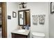 Well-lit bathroom features granite counters, a decorative mirror, and tiled walls at 920 Mellowood Dr, Indianapolis, IN 46217