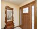 Inviting entryway featuring a solid wood front door and an antique coat rack with mirror at 920 Mellowood Dr, Indianapolis, IN 46217