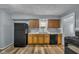 Kitchen featuring wooden cabinets, black appliances, and durable floors at 953 N Oakland Ave, Indianapolis, IN 46201