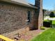 Exterior shot of brick home with partial view of the tidy side yard at 1030 Pamela Dr, Plainfield, IN 46168