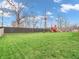 Expansive backyard featuring lush green lawn, a sturdy privacy fence, and a fun playground for outdoor enjoyment at 10603 Hinterland Dr, Fishers, IN 46038