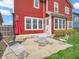 Cozy backyard patio area with outdoor seating, ideal for relaxation and entertaining under a red umbrella and charming red home at 10603 Hinterland Dr, Fishers, IN 46038