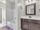 Bathroom boasts a dark wood vanity with white counter and tub with white tile surround at 10603 Hinterland Dr, Fishers, IN 46038