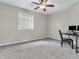 Neutral bedroom with carpet, ceiling fan, and computer desk by the window at 10603 Hinterland Dr, Fishers, IN 46038