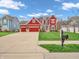 Charming two-story home with red siding, an attached garage, and a well-manicured lawn at 10603 Hinterland Dr, Fishers, IN 46038