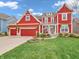 Charming two-story home with red siding, an attached garage, and a well-manicured lawn at 10603 Hinterland Dr, Fishers, IN 46038