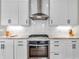 Well-equipped kitchen with white cabinets, granite countertops, stainless steel oven, and tile backsplash at 10603 Hinterland Dr, Fishers, IN 46038