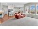 Bright living area with a red leather sofa, seamlessly connecting to the kitchen and adjacent dining area with large windows at 10603 Hinterland Dr, Fishers, IN 46038