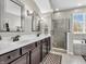 Elegant main bathroom features double sinks, shower, and tiled floors at 10603 Hinterland Dr, Fishers, IN 46038