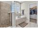 Bright bathroom with tub under window, walk-in shower, and walk-in closet at 10603 Hinterland Dr, Fishers, IN 46038